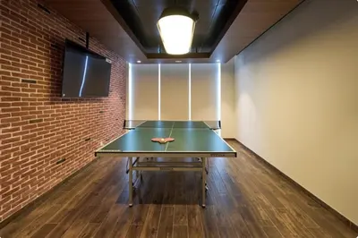 a ping pong table in a room with a brick wall at Iconic Burj Khalifa View - Elegant 1BR Apartment in Dubai