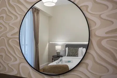 a mirror on a wall with a bed in a room at Designer 2Bedroom in Rimal near to JBR Beach in Dubai