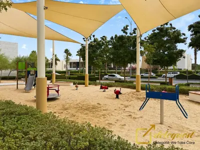 a playground with children playing in the sand under umbrellas at Modern Comfort Studio DAMAC Hills 1 in Dubai