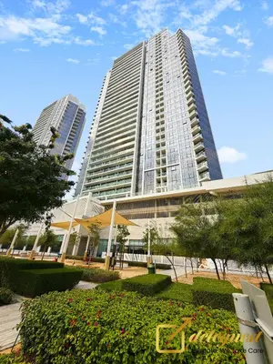 a large building with two tall buildings in the background at Modern Comfort Studio DAMAC Hills 1 in Dubai