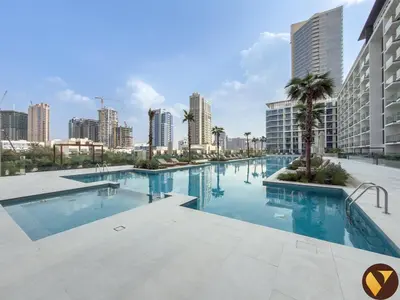 a large swimming pool in a city with tall buildings at Vogue JVC Binghatti Phoenix near Circle Mall, Studio Apartment with Balcony and Access to all Amenities in Dubai