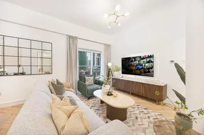 a living room with a couch and a tv at ShoresInn - Sleek & Modern Stay at Dubai Marina in Dubai