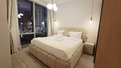 a bedroom with a large white bed with a window at Skyline Vida Dubai Mall 3 Bedroom Apartment I Burj Khalifa Views I Direct Access Dubai Mall I Parking, Gym, Wi-Fi & Pool in Dubai
