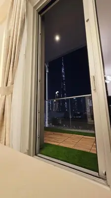 a window with a view of a city at night at Skyline Vida Dubai Mall 3 Bedroom Apartment I Burj Khalifa Views I Direct Access Dubai Mall I Parking, Gym, Wi-Fi & Pool in Dubai