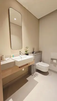 a bathroom with a sink and a toilet and a mirror at Skyline Vida Dubai Mall 3 Bedroom Apartment I Burj Khalifa Views I Direct Access Dubai Mall I Parking, Gym, Wi-Fi & Pool in Dubai