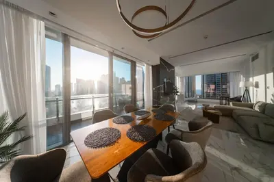 a living room with a table and a large window at Luxury 2BR Huge New Apartment in Dubai