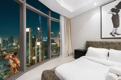 a bedroom with a large window with a city skyline at Luxe 3BR with Infinity Pool and Burj Khalifa View l High Floor in Dubai