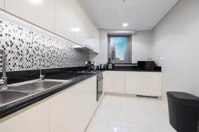 a white kitchen with a sink and a window at Luxe 3BR with Infinity Pool and Burj Khalifa View l High Floor in Dubai