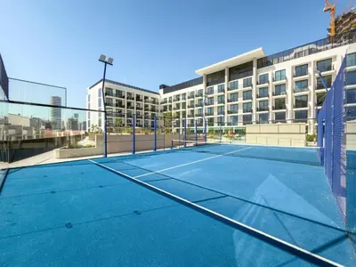 a tennis court in front of a building at Modern Studio in Prime JVC Padel, Pool & Gym in Dubai