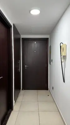 a hallway with a black door and a tile floor at Huge Studio DMCC Metro Close to Marina in Dubai