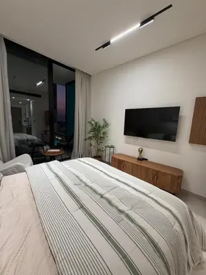 a bedroom with a bed and a flat screen tv at Luxury 1BR Binghatti JVC in Dubai