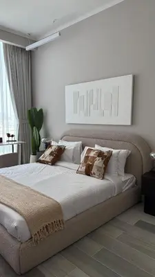 a white bedroom with a large bed with pillows at Stunning Brand New Stylish Studio in JVC in Dubai
