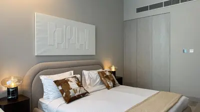 a bedroom with a bed with two pillows on it at Stunning Brand New Stylish Studio in JVC in Dubai