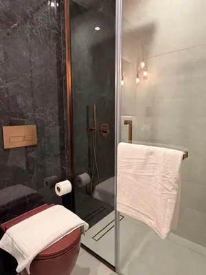 a bathroom with a shower and a toilet with a glass door at HYDE WALK STUDiO BURj ViEW & PREMiUM COMFORt in Dubai