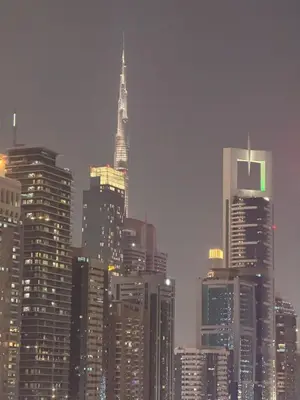 a city skyline with the spire of a tall building at HYDE WALK STUDiO BURj ViEW & PREMiUM COMFORt in Dubai