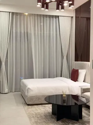 a bedroom with a bed and a table at HYDE WALK STUDiO BURj ViEW & PREMiUM COMFORt in Dubai