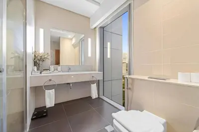 a bathroom with a toilet and a sink and a mirror at DIFC 1 Bed, City View, 600m to Metro, Sleeps 4 in Dubai