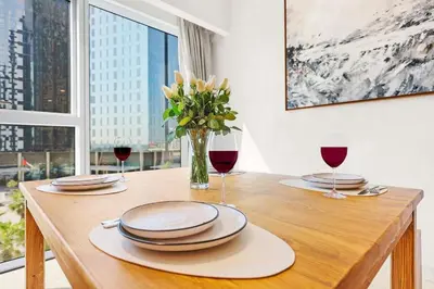 a wooden table with plates and glasses of wine at DIFC 1 Bed, City View, 600m to Metro, Sleeps 4 in Dubai