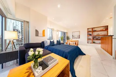 a living room with a couch and a laptop on a table at DIFC 1 Bed, City View, 600m to Metro, Sleeps 4 in Dubai