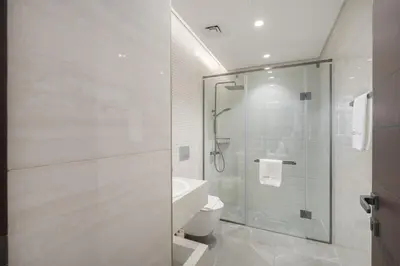 a bathroom with a shower and a toilet and a sink at Premium 1BHK Apartment Nobles Tower by Czechin in Dubai