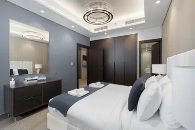 a bedroom with a white bed and a large mirror at Premium 1BHK Apartment Nobles Tower by Czechin in Dubai