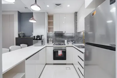 a kitchen with white cabinets and a stove top oven at Premium 1BHK Apartment Nobles Tower by Czechin in Dubai