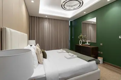 a bedroom with a white bed and a green wall at Premium 1BHK Apartment Nobles Tower by Czechin in Dubai