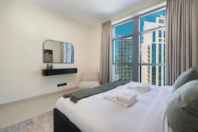 a bedroom with a bed and a large window at Chic 1BR near Burj Khalifa - Downtown in Dubai
