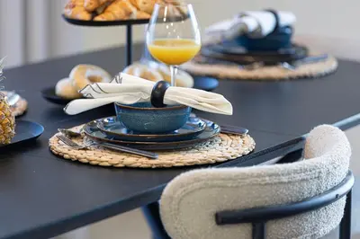 a table with a plate of food and a glass of orange juice at Chic 1BR near Burj Khalifa - Downtown in Dubai