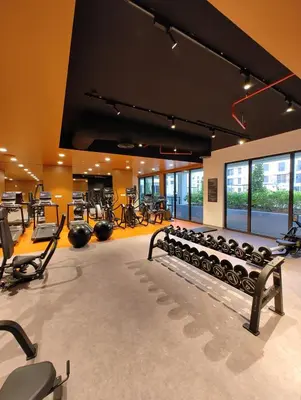 a gym with rows of exercise equipment in a room at Seaside 1-Bedroom Apartment with Beach Access at Port De La Mer in Dubai