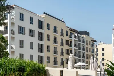 an apartment building with umbrellas and a pool at Seaside 1-Bedroom Apartment with Beach Access at Port De La Mer in Dubai
