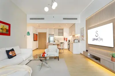 a living room with a white couch and a table at Seaside 1-Bedroom Apartment with Beach Access at Port De La Mer in Dubai