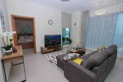 a living room with a couch and a television at Bright 1BR Marina Promenade Partial Sea View in Dubai
