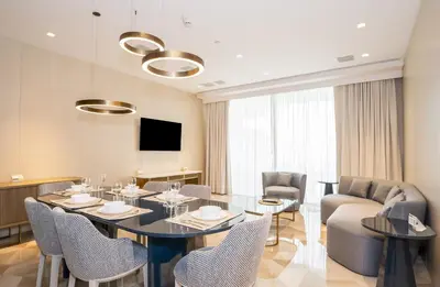a living room with a table and chairs and a couch at New Arabian Five Palm Residences in Dubai