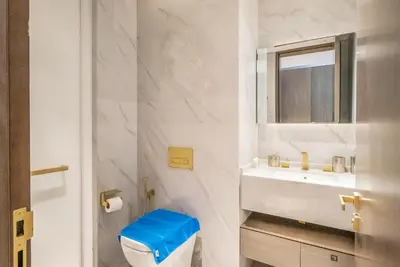 a white bathroom with a toilet and a sink at New Arabian Five Palm Residences in Dubai