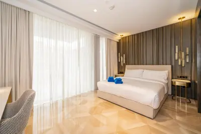 a bedroom with a white bed and a large window at New Arabian Five Palm Residences in Dubai