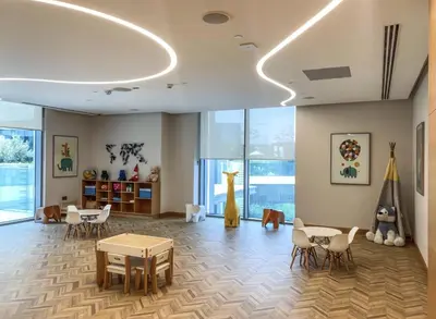 a room with tables and chairs and a giraffe on the wall at Creek Harbour Home Burj Khalifa Downtown View in Dubai
