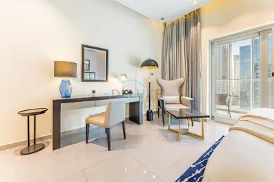 a hotel room with a bed and a desk and chairs at Chic 2BR Apartment, Near Dubai Mall and Fountain - Damac Majestine, Business Bay by Deluxe Holiday Homes in Dubai