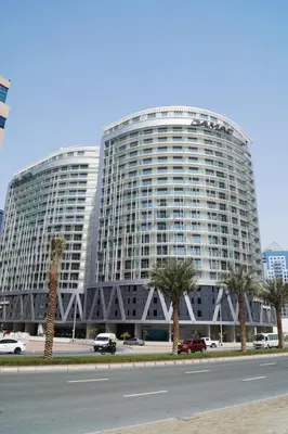 a large building with palm trees in front of it at Chic 2BR Apartment, Near Dubai Mall and Fountain - Damac Majestine, Business Bay by Deluxe Holiday Homes in Dubai