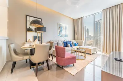 a living room with a dining table and a living room with a view at Chic 2BR Apartment, Near Dubai Mall and Fountain - Damac Majestine, Business Bay by Deluxe Holiday Homes in Dubai
