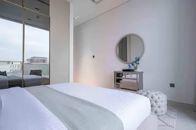 a white bedroom with a large bed and a mirror at Frank Porter - Villa La Mer, Jumeirah 1 in Dubai