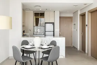 a kitchen and dining room with a table and chairs at Brand New 1BR Apartment In Amalia Residences Al Furjan in Dubai
