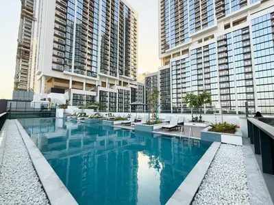 a swimming pool in a building with tall buildings at Stylish & Cozy Fully Furnished 2BR plus Maid Crest C in Dubai