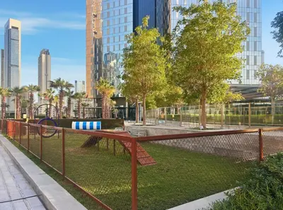 a park in a city with tall buildings at 2BR Duplex DIFC Near Museum of the Future in Dubai