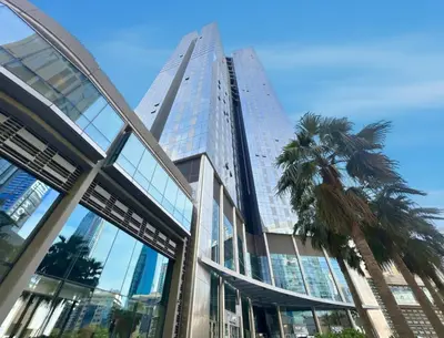 a tall building with a palm tree in front of it at 2BR Duplex DIFC Near Museum of the Future in Dubai