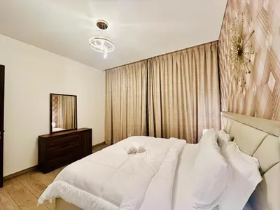 a bedroom with a white bed and a mirror at Greens Community View Spacious 1BR Fully Furnished in Dubai