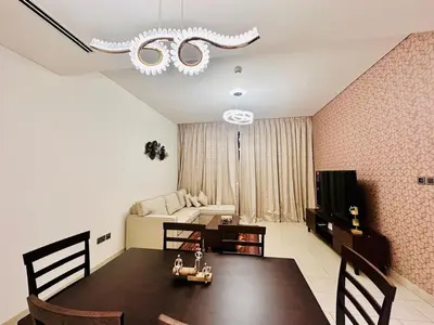 a room with a dining table and a living room at Greens Community View Spacious 1BR Fully Furnished in Dubai
