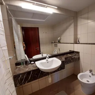 a bathroom with a sink and a toilet and a mirror at Modern 1BR Duplex Jumeirah Bay X1-1 In JLT in Dubai