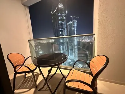 a balcony with a table and chairs and a view of a city at Brand New 1BR in Creek Vista Grande in Dubai