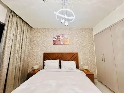 a bedroom with a large bed and a chandelier at Brand New 1BR in Creek Vista Grande in Dubai